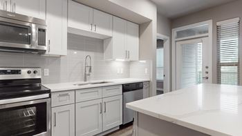 A kitchen with white cabinets and a white counter top